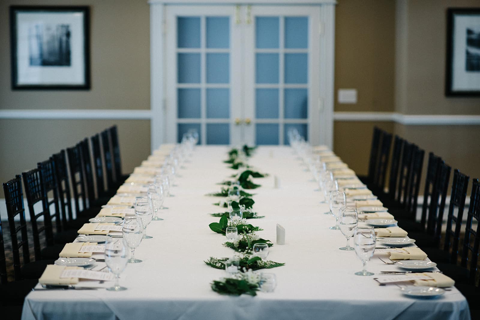 Several barrels lined up in front of a barn.