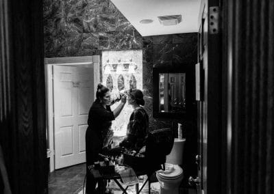 Bride getting makeup done in suite