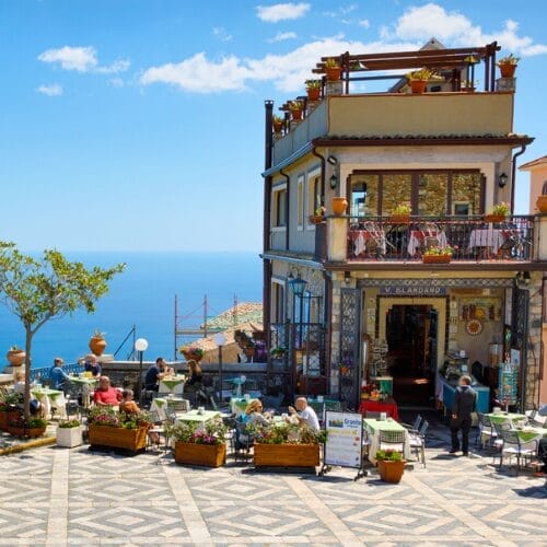 People dining at a Sicilian restaurant on the ocean.