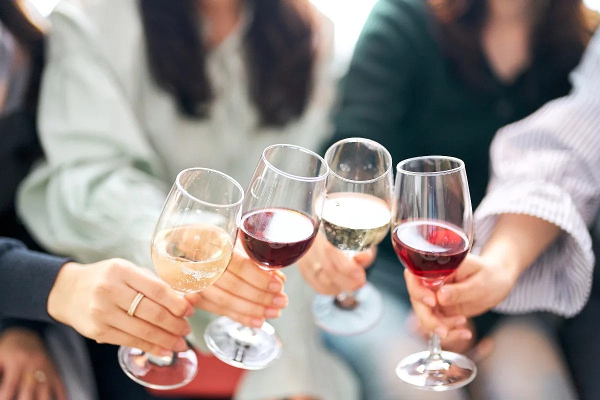 People toasting with glasses of wine.