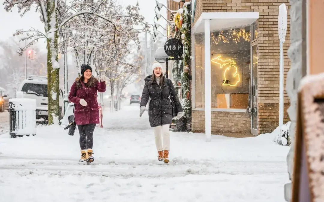 Two women walking in downtown Traverse City while it is snowing